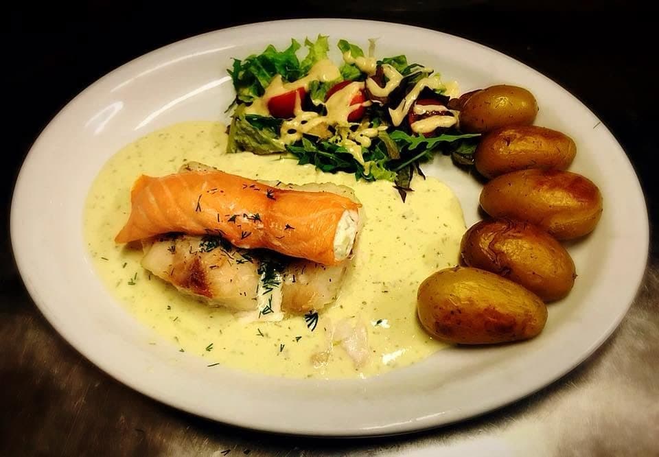 Un filet de saumon roulé dans une sauce claire, avec des pommes de terre grenaille et une petite salade